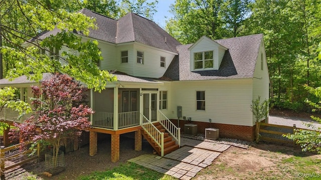 rear view of house featuring roof with shingles, fence, a patio, and a sunroom