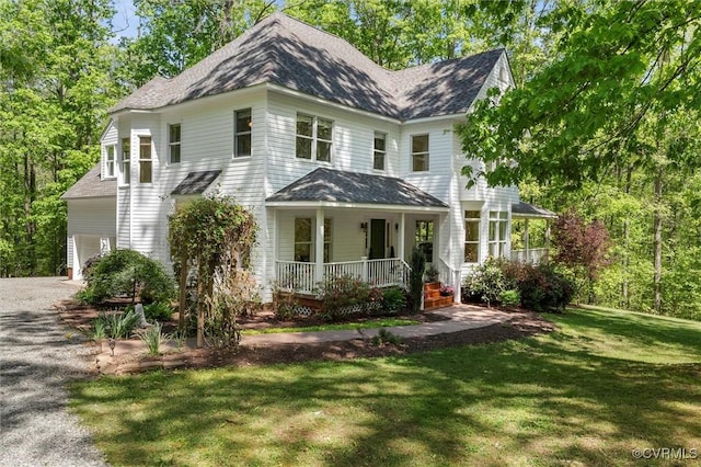 view of front of property with a shingled roof, a porch, driveway, and a front yard