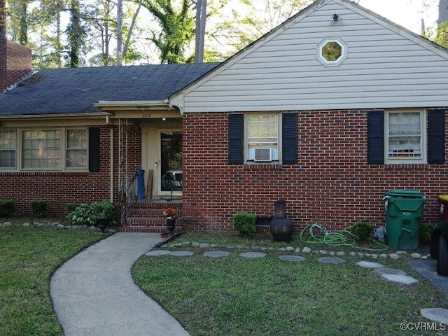 ranch-style house with brick siding, a chimney, and a front lawn