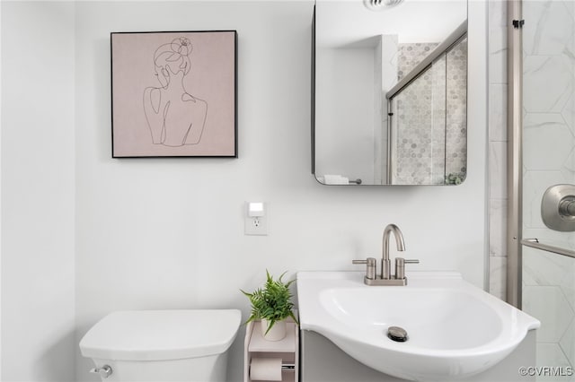 full bathroom featuring toilet, a stall shower, and a sink