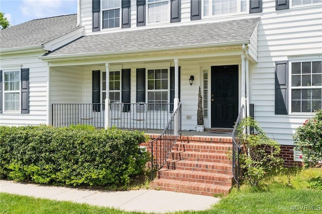 property entrance with a porch and roof with shingles