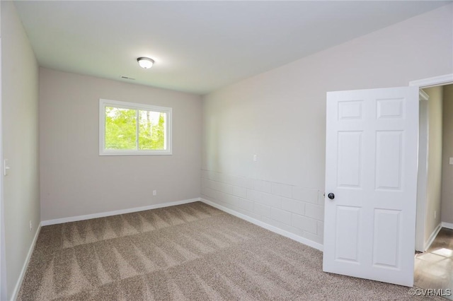 unfurnished room with light carpet and baseboards