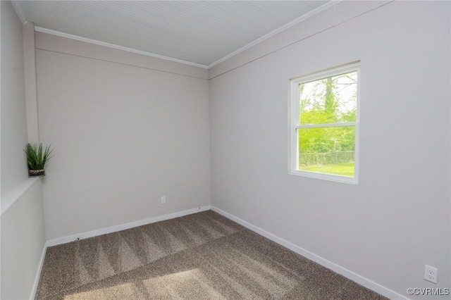 carpeted spare room with baseboards, ornamental molding, and plenty of natural light