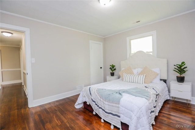 bedroom featuring wood finished floors, visible vents, crown molding, and baseboards