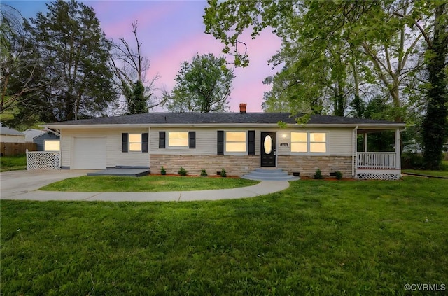 ranch-style house featuring concrete driveway, a chimney, a front yard, and a garage