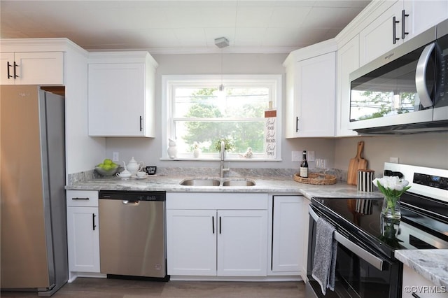 kitchen featuring a wealth of natural light, appliances with stainless steel finishes, a sink, and white cabinetry
