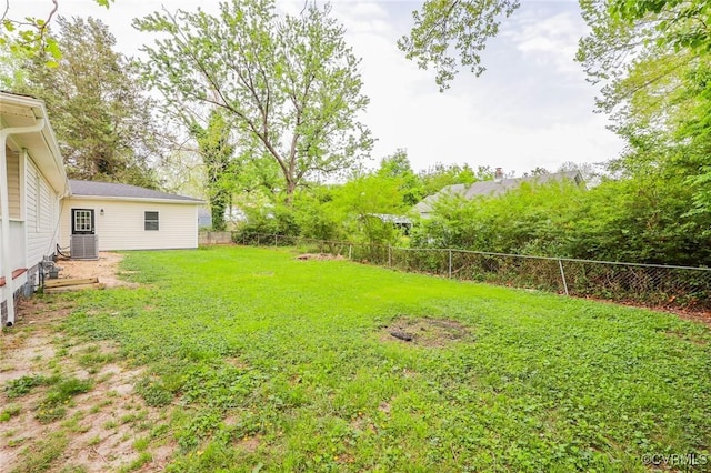 view of yard with a fenced backyard and central AC unit