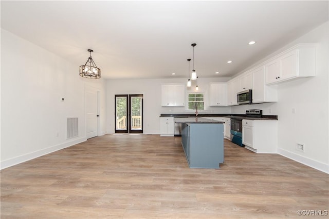 kitchen with dark countertops, visible vents, white cabinetry, and appliances with stainless steel finishes