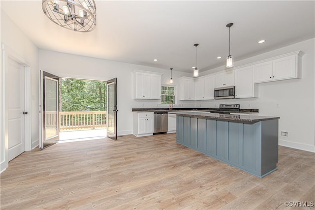 kitchen with light wood-style floors, an inviting chandelier, white cabinetry, appliances with stainless steel finishes, and recessed lighting