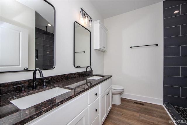 full bath featuring baseboards, wood finished floors, a sink, and visible vents