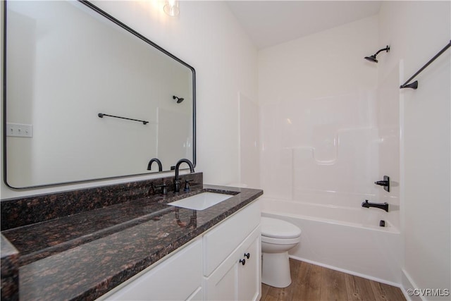 full bath with toilet, vanity, wood finished floors, and shower / tub combination