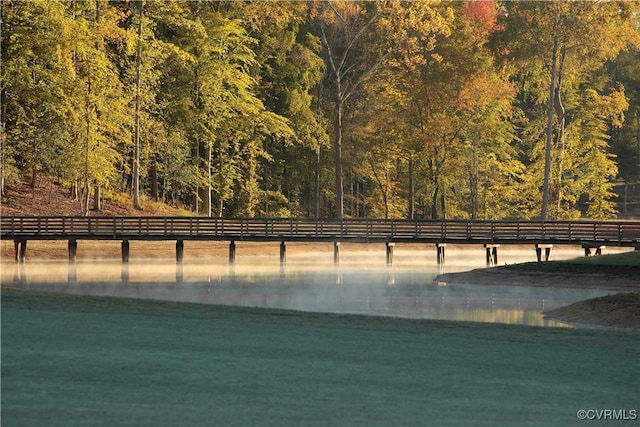 exterior space with a forest view and a water view