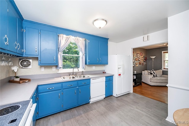 kitchen with a sink, decorative backsplash, white appliances, and blue cabinetry