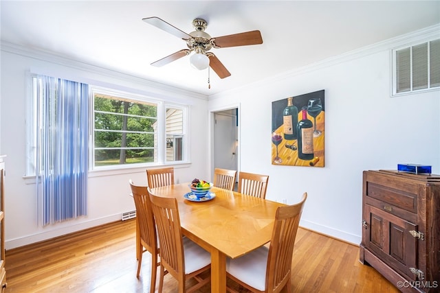 dining area featuring a ceiling fan, visible vents, baseboards, light wood-style floors, and ornamental molding