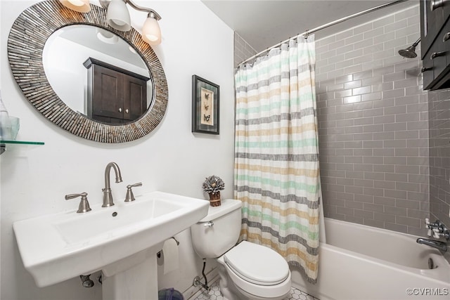 bathroom featuring a sink, shower / bath combination with curtain, and toilet
