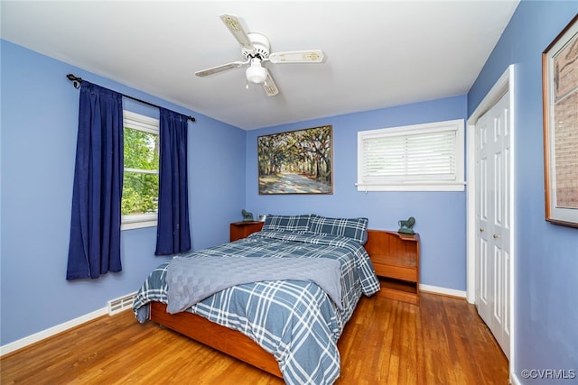 bedroom featuring baseboards, wood finished floors, and a closet