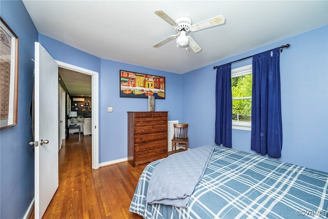 bedroom with baseboards, ceiling fan, and wood finished floors