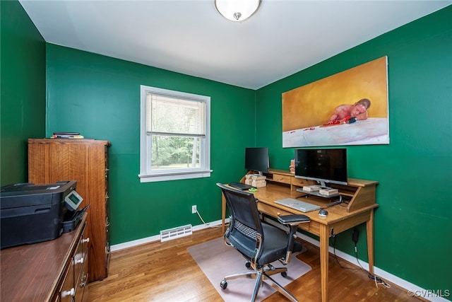 home office with baseboards, wood finished floors, and visible vents