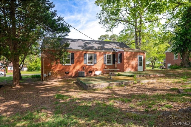 back of property featuring brick siding, crawl space, and cooling unit