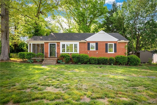 single story home with brick siding and a front yard