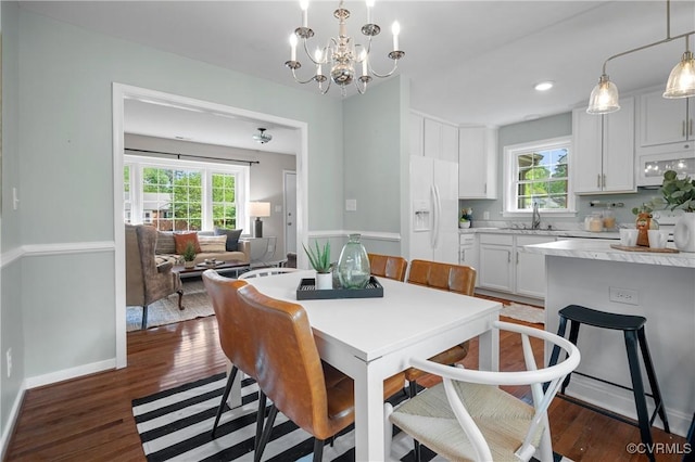 dining room featuring dark wood finished floors, a chandelier, and a wealth of natural light