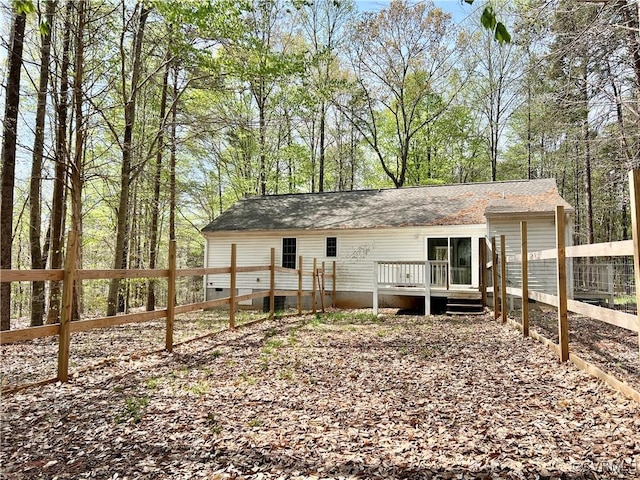 exterior space with a wooden deck, crawl space, fence, and a shingled roof
