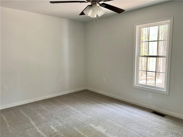 empty room featuring baseboards, a ceiling fan, and visible vents