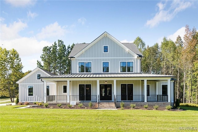 modern farmhouse style home featuring board and batten siding, a porch, a front yard, metal roof, and a standing seam roof