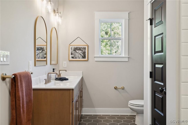 bathroom featuring vanity, toilet, baseboards, and tile patterned floors