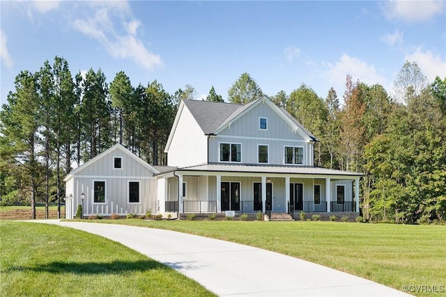 modern inspired farmhouse featuring a front lawn, board and batten siding, a standing seam roof, a porch, and metal roof