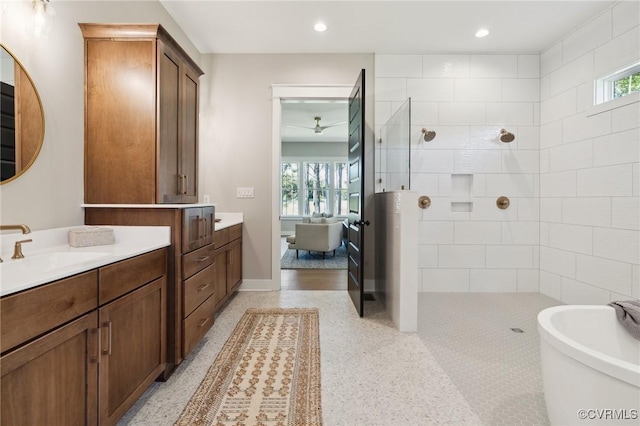 bathroom featuring a soaking tub, vanity, a walk in shower, and recessed lighting