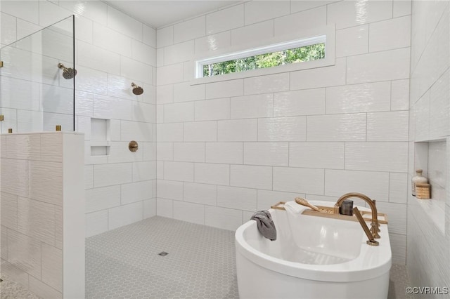 bathroom with tile walls, a freestanding tub, and tiled shower