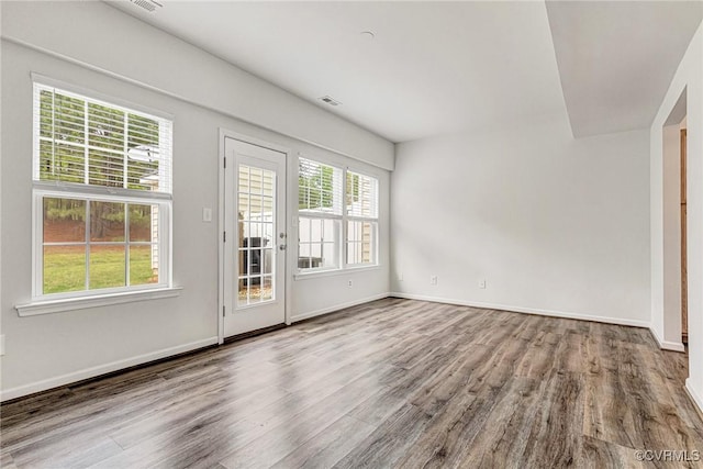interior space with wood finished floors, visible vents, and baseboards