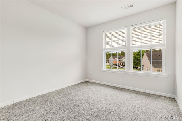 carpeted empty room with baseboards and visible vents