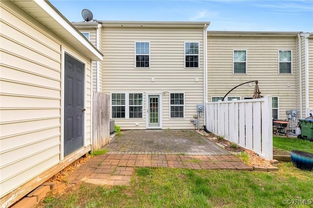 back of property with fence and a patio