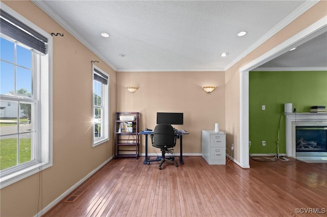 office area featuring baseboards, ornamental molding, hardwood / wood-style floors, and a wealth of natural light