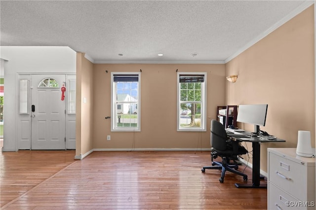 office area with baseboards, ornamental molding, light wood finished floors, and a textured ceiling