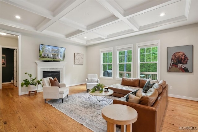 living area featuring coffered ceiling, baseboards, light wood finished floors, a high end fireplace, and beam ceiling