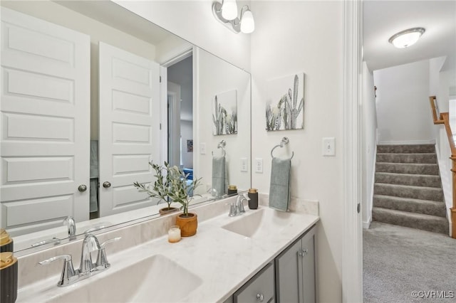 bathroom with a sink, double vanity, and baseboards