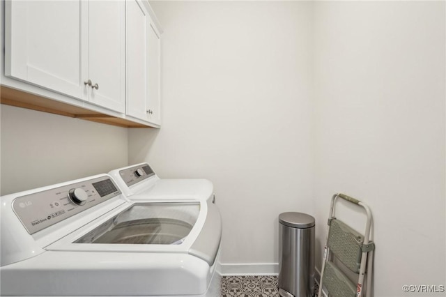 washroom with cabinet space, washer and clothes dryer, and baseboards