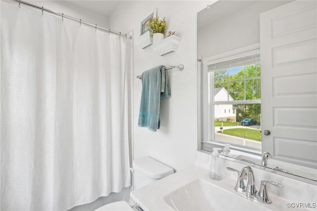 bathroom featuring toilet, vanity, and a shower with shower curtain
