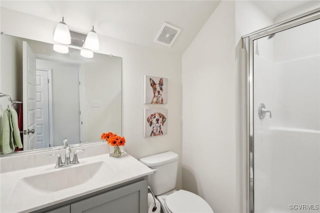 bathroom with vanity, toilet, visible vents, and a stall shower