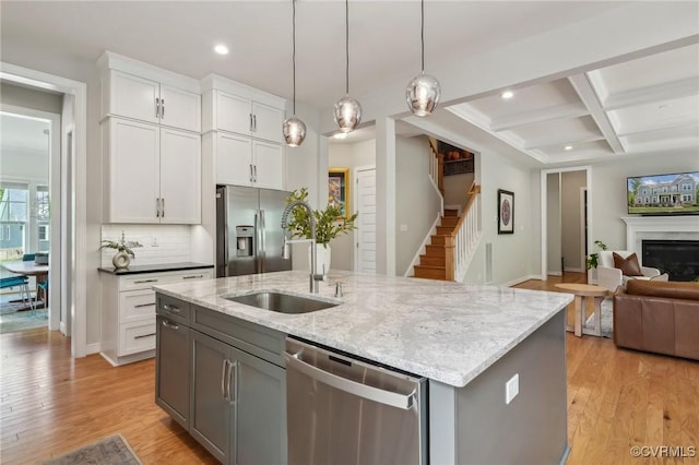 kitchen featuring a sink, a kitchen island with sink, recessed lighting, open floor plan, and appliances with stainless steel finishes
