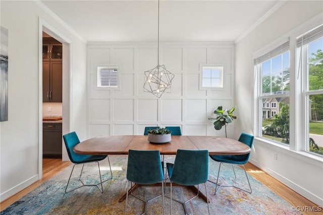 dining area with ornamental molding, baseboards, visible vents, and wood finished floors
