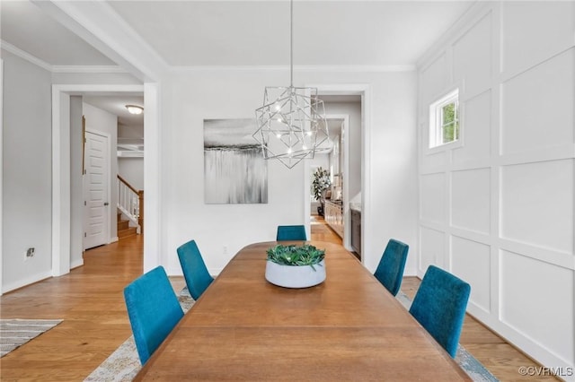 dining space with an inviting chandelier, light wood-type flooring, stairway, and ornamental molding