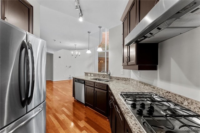 kitchen featuring dark brown cabinets, a sink, an inviting chandelier, appliances with stainless steel finishes, and under cabinet range hood