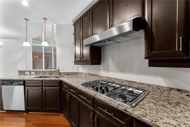 kitchen with dark brown cabinets, appliances with stainless steel finishes, under cabinet range hood, and a sink