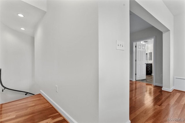 hallway with baseboards, recessed lighting, and wood-type flooring