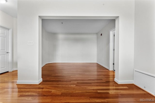 corridor featuring baseboards and wood finished floors