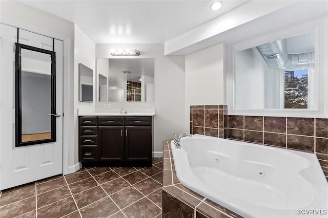 bathroom with baseboards, vanity, tile patterned floors, and a jetted tub
